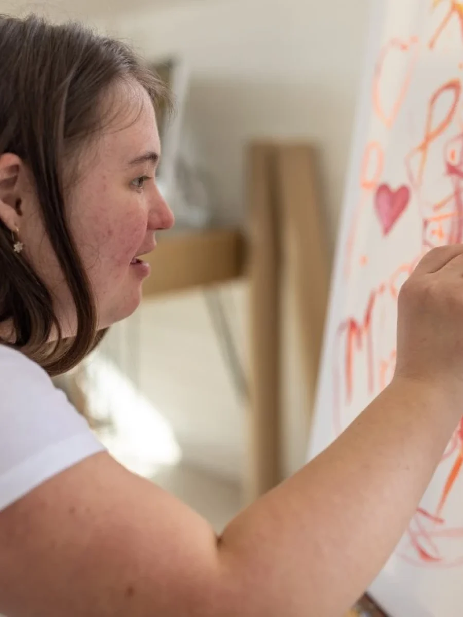 Girl with down syndrome painting in art class